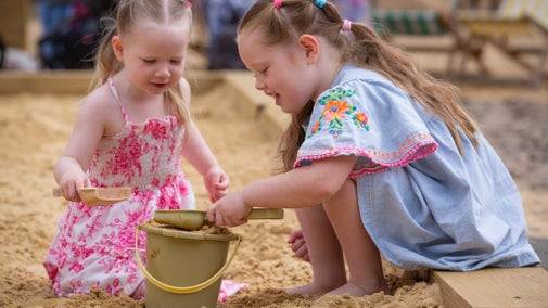Children playing in the sand at the urban beach during the Summer of Play event at Tredegar House, Newport
